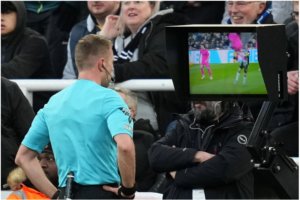 Referee Samuel Barrott consults the VAR monitor at Newcastle United